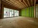 Unfinished living room featuring stud framing, exterior sheathing, and sliding glass doors at 1523 Sunrise Ave, Raleigh, NC 27608