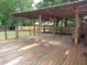Spacious covered porch with weathered wooden deck, offering ample room for outdoor gatherings at 1610 W B St, Butner, NC 27509