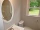 Bathroom featuring a sink, toilet, and mirror at 1610 W B St, Butner, NC 27509