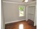 Neutral bedroom featuring hardwood floors, one window, and a closet at 1610 W B St, Butner, NC 27509