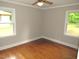 Cozy bedroom showcases hardwood floors, two windows and a ceiling fan at 1610 W B St, Butner, NC 27509