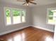 Bright bedroom featuring hardwood floors, neutral walls, and natural light from large windows at 1610 W B St, Butner, NC 27509