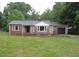 Exterior shot showcases a well-maintained home with a manicured lawn and stone accents at 1610 W B St, Butner, NC 27509