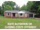 Charming brick home featuring a well-manicured front yard, a black roof, and an attached garage at 1610 W B St, Butner, NC 27509