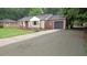 Inviting home with a stone and brick facade, complemented by a newly paved driveway and lush landscaping at 1610 W B St, Butner, NC 27509
