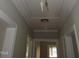 Hallway with light gray walls, white trim, and access to attic at 1610 W B St, Butner, NC 27509