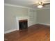 Bright living room with a traditional fireplace, hardwood floors, and custom built-ins at 1610 W B St, Butner, NC 27509