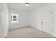 Neutral bedroom featuring carpeted floors, a window for natural light, and white trim at 169 Nashua Dr # 2590P, Louisburg, NC 27549