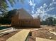 Exposed framing and partially completed roof on a home under construction surrounded by lumber and materials at 194 Landon Ridge, Sanford, NC 27330