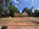 New construction home featuring a framed structure with a wooded backdrop under a blue sky at 194 Landon Ridge, Sanford, NC 27330