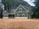 Green two-story home with white trim, black roof, and attached garage in a wooded setting at 194 Landon Ridge, Sanford, NC 27330