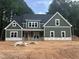 New two-story home with green siding, white trim, and black roof, surrounded by trees at 194 Landon Ridge, Sanford, NC 27330