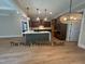 Open kitchen with a large island, custom cabinets, and modern pendant lighting and wood-style flooring at 194 Landon Ridge, Sanford, NC 27330
