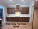 Modern kitchen featuring custom wood cabinets, light countertops, subway tile backsplash, and range hood at 194 Landon Ridge, Sanford, NC 27330