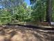 A large lot is partially cleared of trees and brush with a silt fence surrounding the construction zone at 194 Landon Ridge, Sanford, NC 27330
