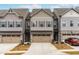 Charming townhome exterior with a two-car garage and beautifully landscaped front yard at 2140 Stegemann St, Apex, NC 27502