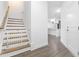 Hallway with wood stairs and a baby gate, leading to an open-concept kitchen and living area at 2140 Stegemann St, Apex, NC 27502