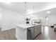 Kitchen island with stainless steel dishwasher and sink opens to the living area with a fireplace at 2140 Stegemann St, Apex, NC 27502