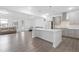 Open-concept living area featuring a kitchen island and a cozy seating area with natural light at 2140 Stegemann St, Apex, NC 27502