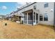 Exterior view of a row of townhomes with screened-in porches and well-maintained backyard at 2140 Stegemann St, Apex, NC 27502