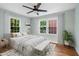 Light-filled bedroom featuring hardwood floors, a ceiling fan, and windows overlooking the neighborhood at 2206 Guess Rd, Durham, NC 27705