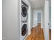 Hallway with stacked washer and dryer and hardwood floors at 2206 Guess Rd, Durham, NC 27705