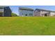 A spacious backyard with lush grass and a view of the home's exterior and neighborhood at 244 Potomac River St, Garner, NC 27529