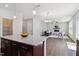 Kitchen island with granite countertop is open to the living room with modern finishes at 244 Potomac River St, Garner, NC 27529