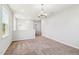 Bright living room featuring neutral walls, plush carpet, and elegant modern light fixtures at 244 Potomac River St, Garner, NC 27529