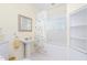 Bright bathroom featuring a single pedestal sink, a floral curtain, white tile, and a framed mirror at 2440 Glencoe St, Burlington, NC 27217