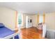 Bedroom with light yellow walls, hardwood flooring, and a large window providing natural light at 2440 Glencoe St, Burlington, NC 27217