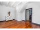 Bedroom featuring hardwood floors, white walls, and access to additional rooms in the home at 2440 Glencoe St, Burlington, NC 27217