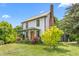 Charming two-story home featuring a metal roof, brick chimney, and beautifully landscaped yard at 2440 Glencoe St, Burlington, NC 27217