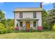 Charming two-story home with a quaint front porch, rocking chairs, porch swing and beautiful landscaping at 2440 Glencoe St, Burlington, NC 27217