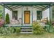 Inviting front porch with rocking chairs, porch swing, and a charming wreath on the front door at 2440 Glencoe St, Burlington, NC 27217