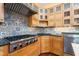 Well-equipped kitchen features a stainless steel range, custom cabinetry and backsplash, and a black countertop at 2440 Glencoe St, Burlington, NC 27217