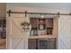 Wet bar with sliding barn door, custom cabinets, marble countertops and beverage center at 2912 Epps Clark Rd, Siler City, NC 27344
