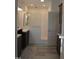 Beautiful bathroom with a glass-enclosed shower, dual vanities, and stylish wood-look flooring at 2912 Epps Clark Rd, Siler City, NC 27344