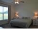Cozy bedroom featuring a neutral color scheme, ceiling fan, and natural light from a large window at 2912 Epps Clark Rd, Siler City, NC 27344