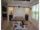 A dining room with a large wooden table, white chairs, and barn doors leading to a bar area at 2912 Epps Clark Rd, Siler City, NC 27344