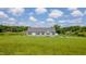 Well-maintained house with a lush green lawn, driveway, and mature trees under a bright sky at 2912 Epps Clark Rd, Siler City, NC 27344