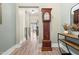 Inviting hallway featuring hardwood floors, neutral paint, and classic grandfather clock at 345 Warm Wind Dr, Clayton, NC 27527