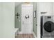 Bright laundry room features a modern washer and dryer, decorative wreath, and stylish wallpaper at 345 Warm Wind Dr, Clayton, NC 27527