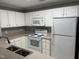 Well-lit kitchen with white appliances, ample counter space, and double bowl stainless steel sink at 3489 Forestdale Dr # 2D, Burlington, NC 27215