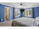 Bright bedroom features blue walls, a ceiling fan, TV, and two windows with natural light at 368 Bayleigh Ct, Garner, NC 27529