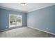 Serene bedroom with neutral carpet, light blue walls, and a large window letting in natural light at 368 Bayleigh Ct, Garner, NC 27529