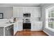 Well-lit kitchen featuring stainless steel appliances, shaker cabinets, and hardwood flooring at 368 Bayleigh Ct, Garner, NC 27529