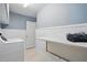 Bright laundry room with washer, bench, beadboard and ample storage at 368 Bayleigh Ct, Garner, NC 27529