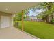 View of the grassy backyard with a white house and fenced property line, seen from the covered porch at 408 W Stallings St, Clayton, NC 27520