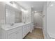 Bathroom features double vanity, framed mirrors, wood floor, and a shower with a glass door at 408 W Stallings St, Clayton, NC 27520
